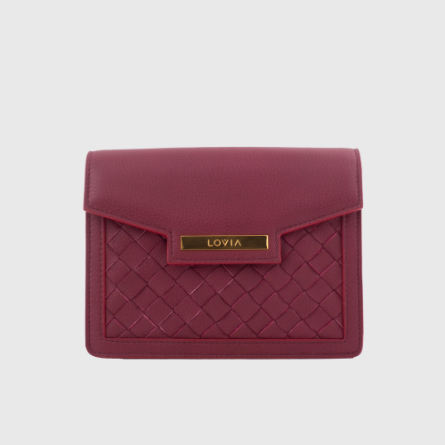 Lovia Kaiho burgundinvärinen nahkainen crossbody-laukku, jossa punottu paneeli ja kullanväriset yksityiskohdat. | Lovia Kaiho burgundy leather crossbody bag with woven panel and gold details.