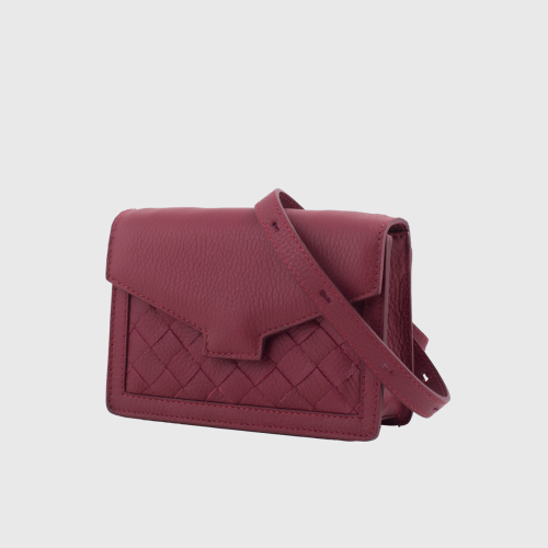 Lovia Hilla viininpunainen nahkainen crossbody-laukku, jossa punottu paneeli ja säädettävä hihna. | Lovia Hilla burgundy leather crossbody bag with woven panel and adjustable strap.